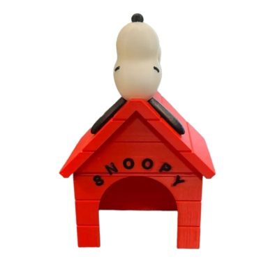 Snoopy sur une niche rouge avec le nom "SNOOPY" en lettres noires.